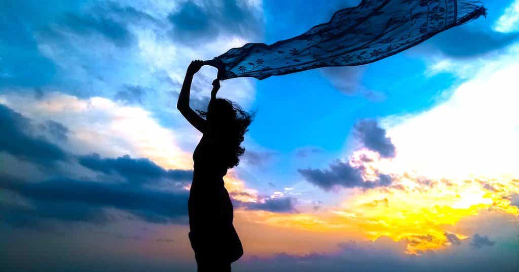 mujer con velo al viento simbolizando la abundancia