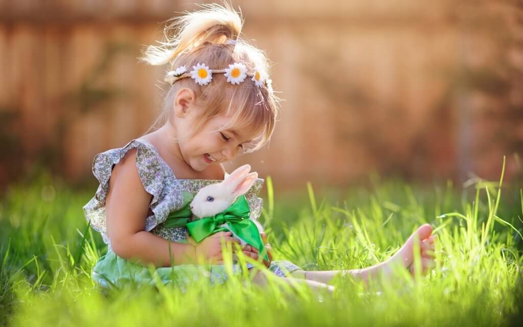 Niña con conejo en el campo