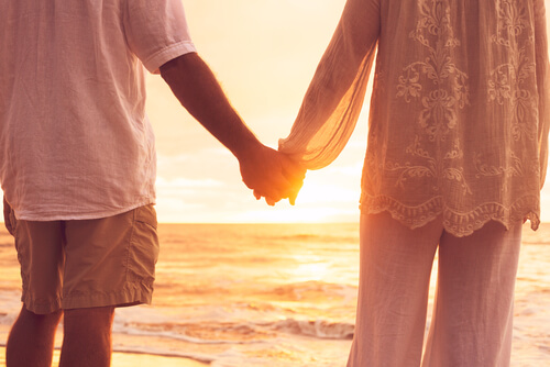 Pareja agarrada de la mano en la playa