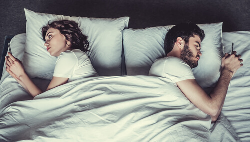 Pareja dándose la espalda en la cama