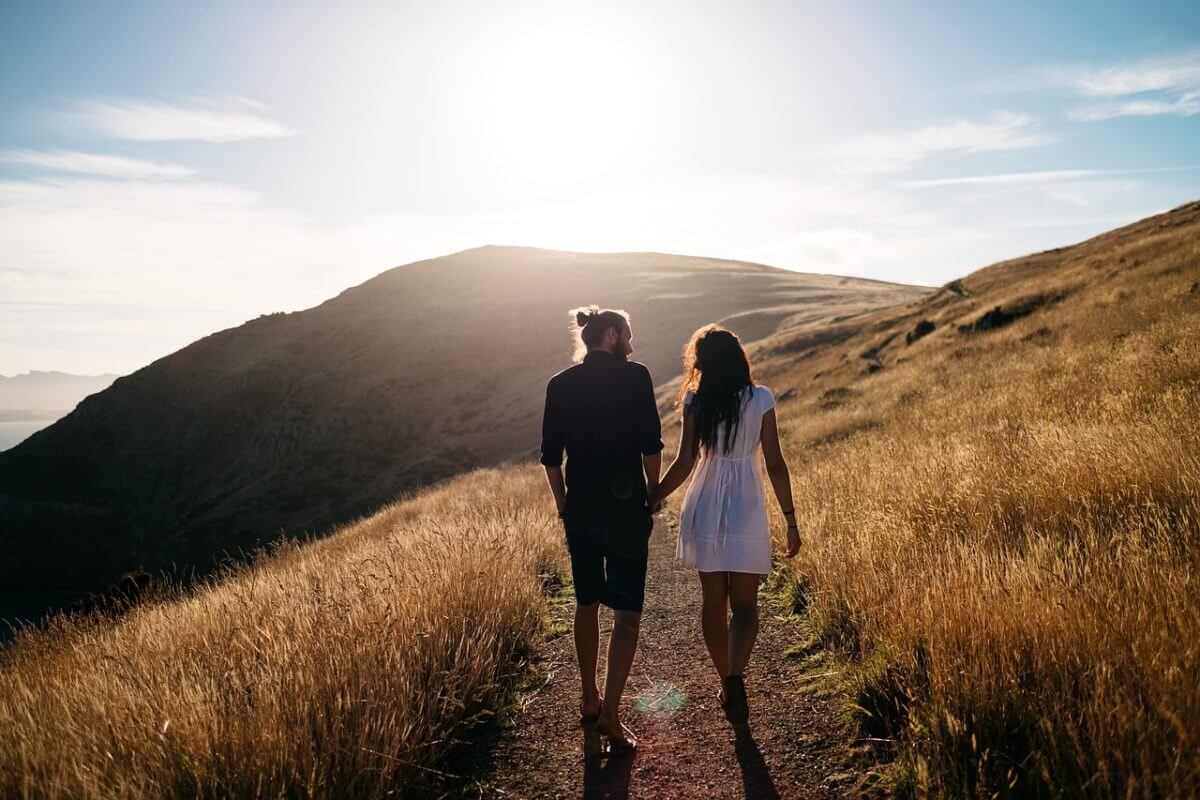 Pareja paseando por el campo de espaldas