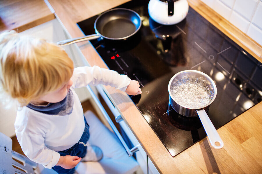 Baby in the kitchen with ceramic hob Baby in the kitchen with ceramic hob