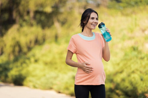Embarazada bebiendo agua tras hacer running