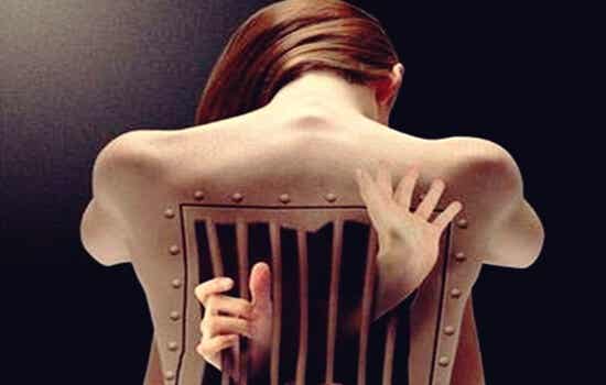 mujer con cárcel imagen simbolizando cómo afectan las emociones a la espalda