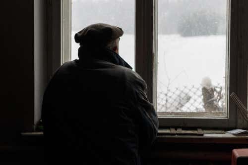 Hombre con alzheimer mirando por la ventana
