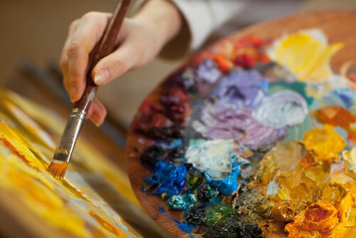Mano con pincel pintando al oleo representando la relación entre la creatividad y el trastorno bipolar
