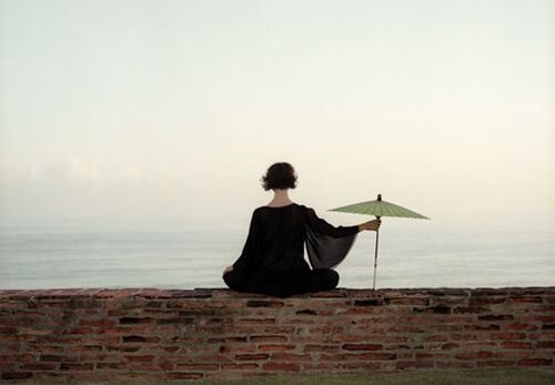 mujer con sombrilla sintiendo el silencio interior