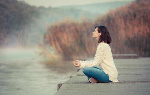 Mujer haciendo mindfulness cerca de un lago