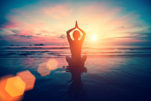 Mujer haciendo yoga en el mar