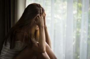 Mujer triste mirando por la ventana