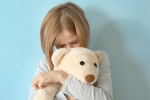 Niña triste con un peluche