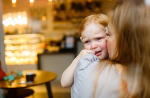 Niña pequeña llorando en brazos de su madre