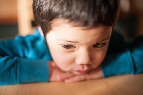 Niño triste tumbado
