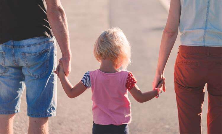 Padres agarrados de la mano por su hijo