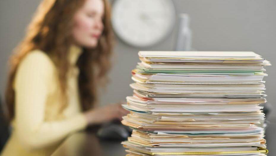 chica con papeles acumulados simbolizando el miedo está dominando tu vida