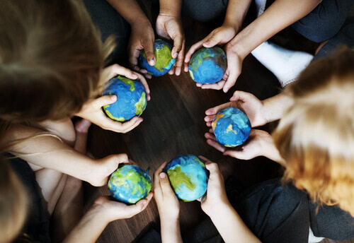 Personas con bolas del mundo en las manos