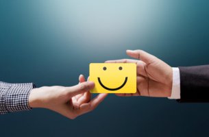 Empresario y cliente sujetando nota con una cara sonriente