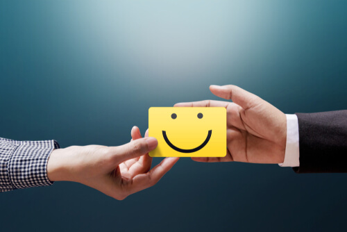 Empresario y cliente sujetando nota con una cara sonriente