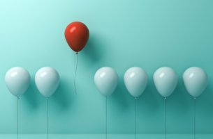 Globos blancos con uno rojo para representar el efecto de Von Restorff