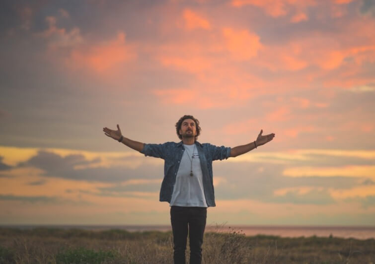 hombre con brazos extendidos haciendo una plegaria personal