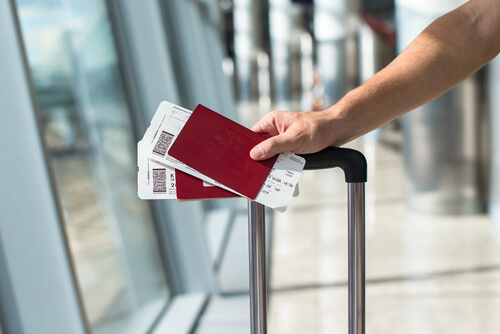 Mano de una persona con billetes para viajar