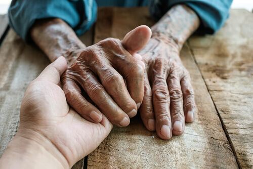 Mãos de um adulto e de uma pessoa idosa