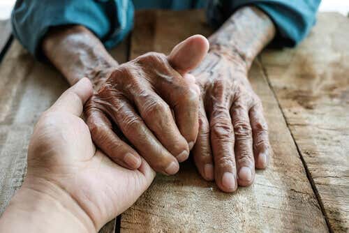Mani di un adulto e di una persona anziana