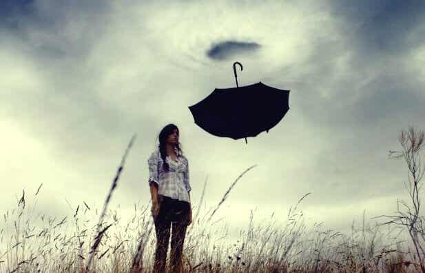 mujer ante paraguas que sufre angustia emocional