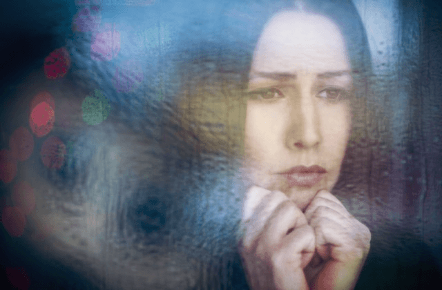 Mujer triste mirando por la ventana