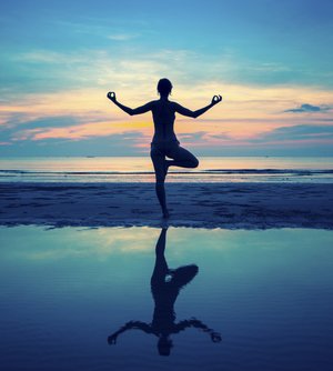 Mujer en equilibrio en la playa para representar el equilibrio psicológico