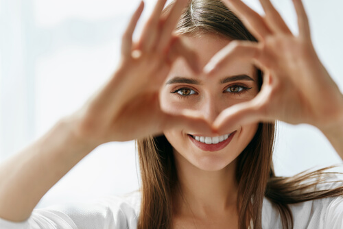 Mujer haciendo un corazón con sus manos