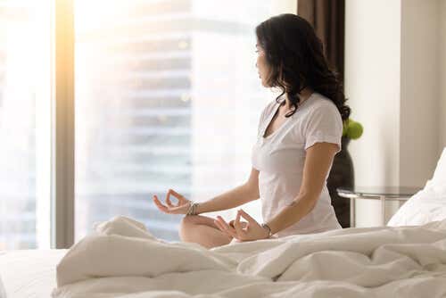 Mujer meditando en su habitación por el método miracle morning