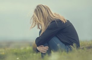 Mujer con inseguridad emocional sentada en el campo