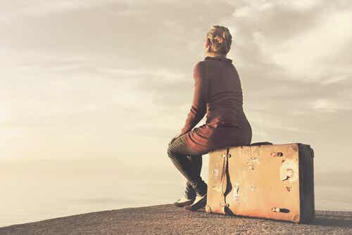 Mujer sentada sobre una maleta simbolizando el hecho de que viajar mejora tu salud cerebral