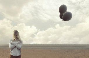 Mujer sujetando un globo negro