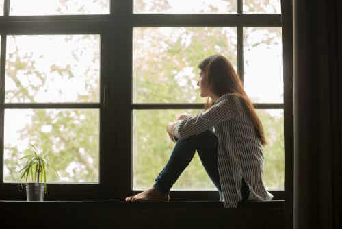 Mujer triste sentada en una ventana