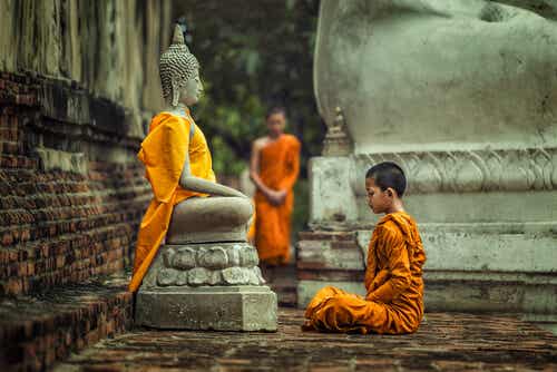 Niño frente a una figura de Buda