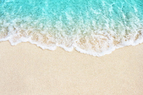 Ola desvaneciéndose en la arena