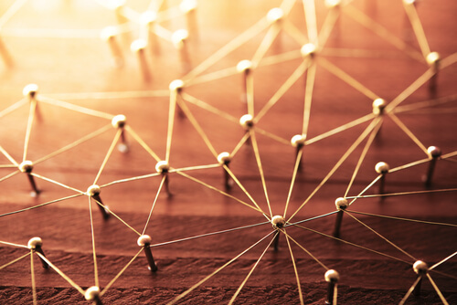 Clavos con hilos conectados simbolizando la regla de los tres grados de influencia