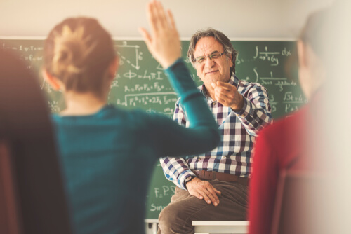 Profesor señalando a una alumna