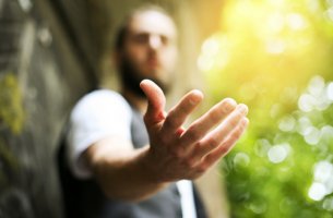 Hombre con la mano abierta para representar el complejo de salvador