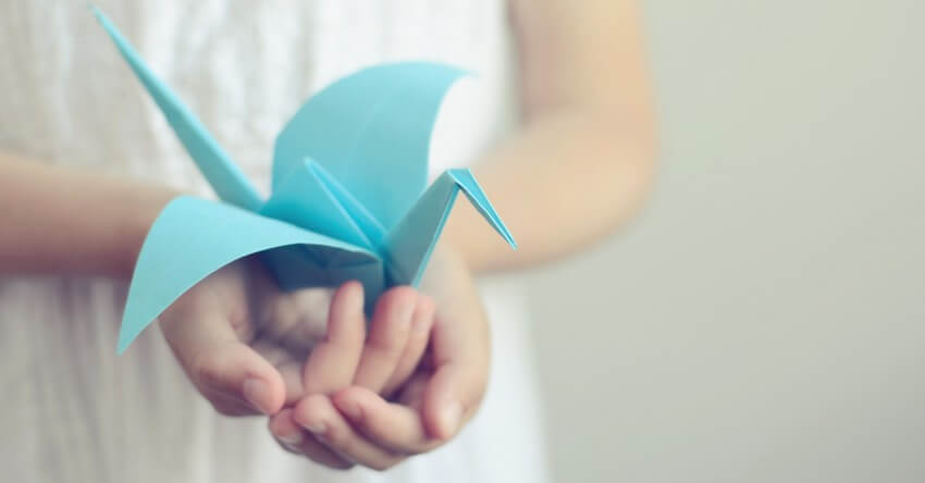 mano con pajarita de papel simbolizando la idea de ¿pides perdón con frecuencia?