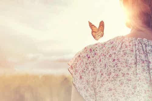 Kvinne med en sommerfugl på skulderen som tenker på å vite hvordan hun skal vente