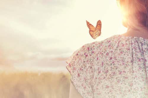 Mujer con una mariposa en el hombro pensando que todo cambia