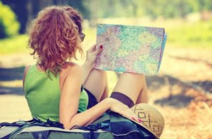 mujer de espaldas con mapa en la mano simbolizando el hecho de que viajar mejora tu salud cerebral