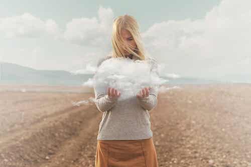 Mujer con una nube entre sus manos pensando en los problemas emocionales que tiene