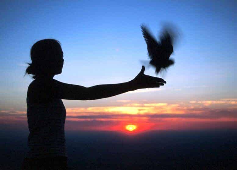 Mujer soltando un pájaro para trabajar los 8 dharmas mundanos