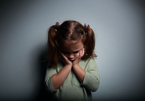 Niña triste por tener padres ausentes emocionalmente