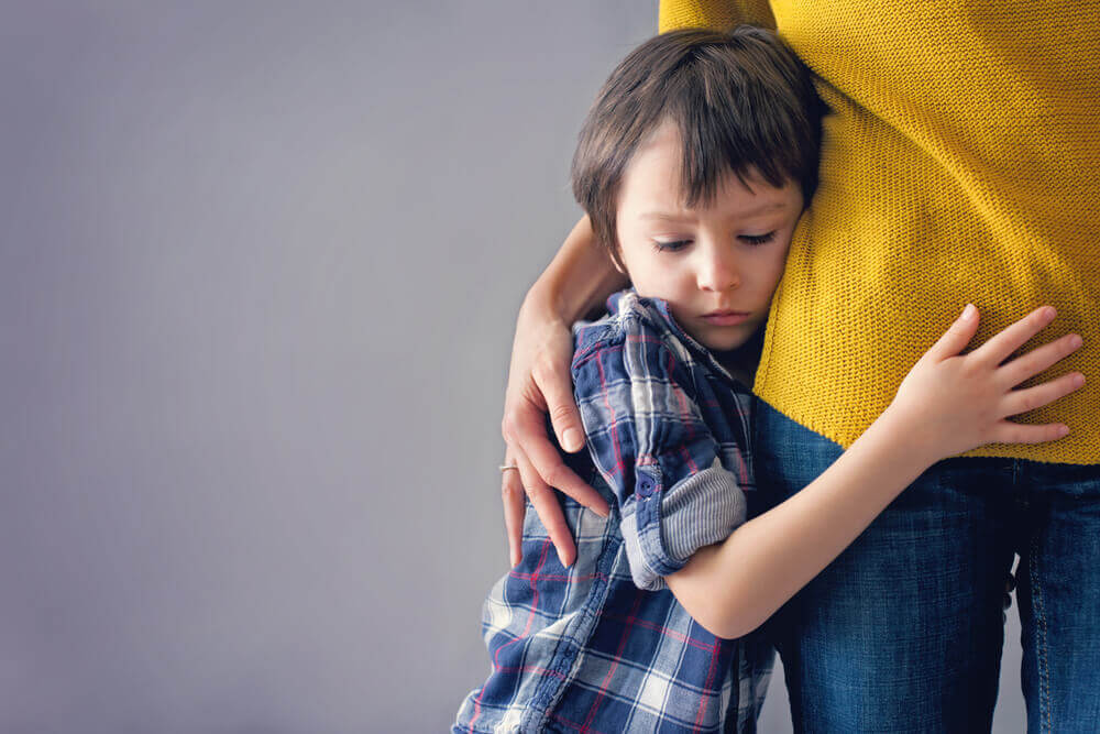 Niño abrazado a su madre
