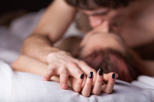 Couple s'embrassant au lit pour représenter la pratique du cocu